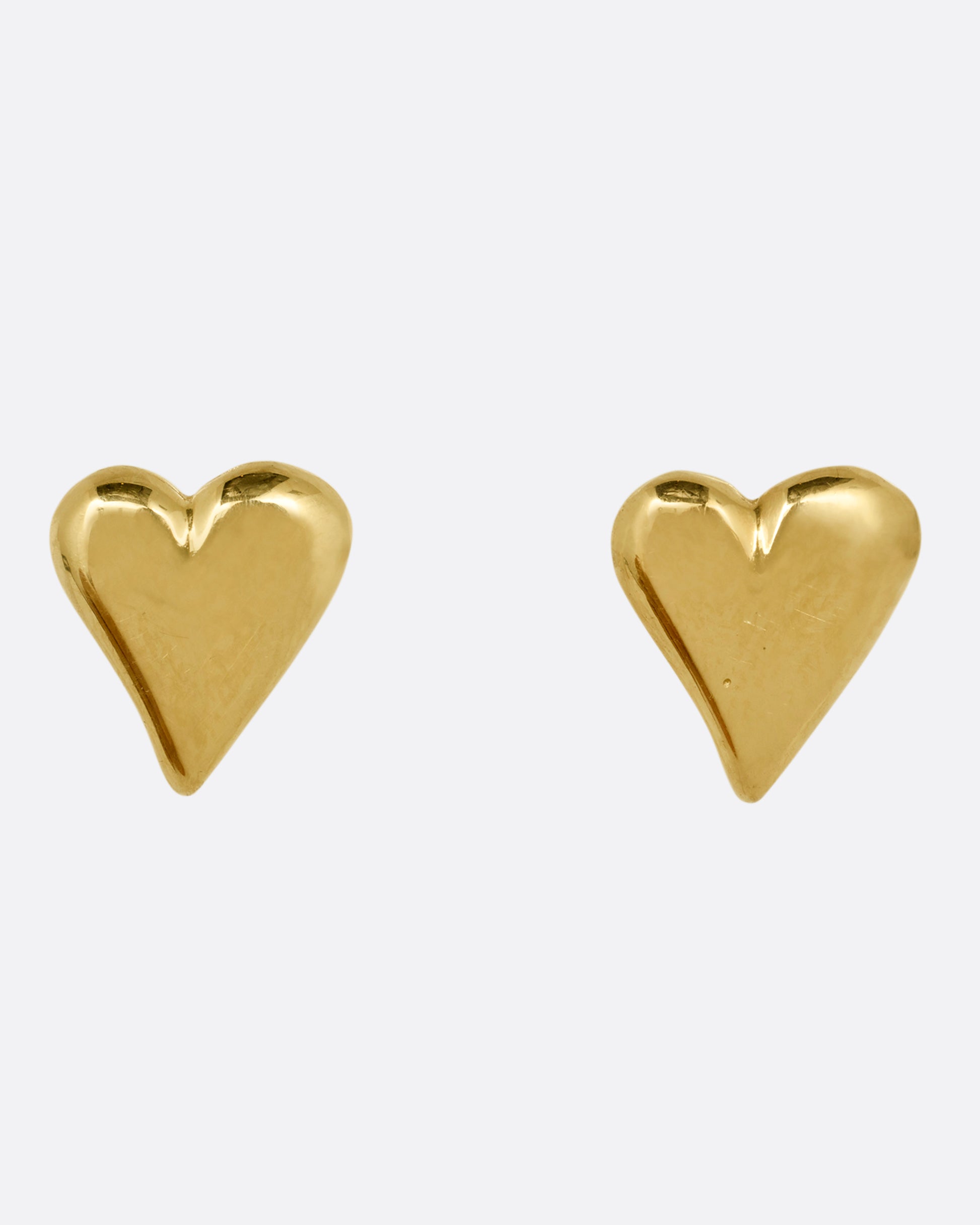 A pair of yellow gold heart earrings. Shown from the front.