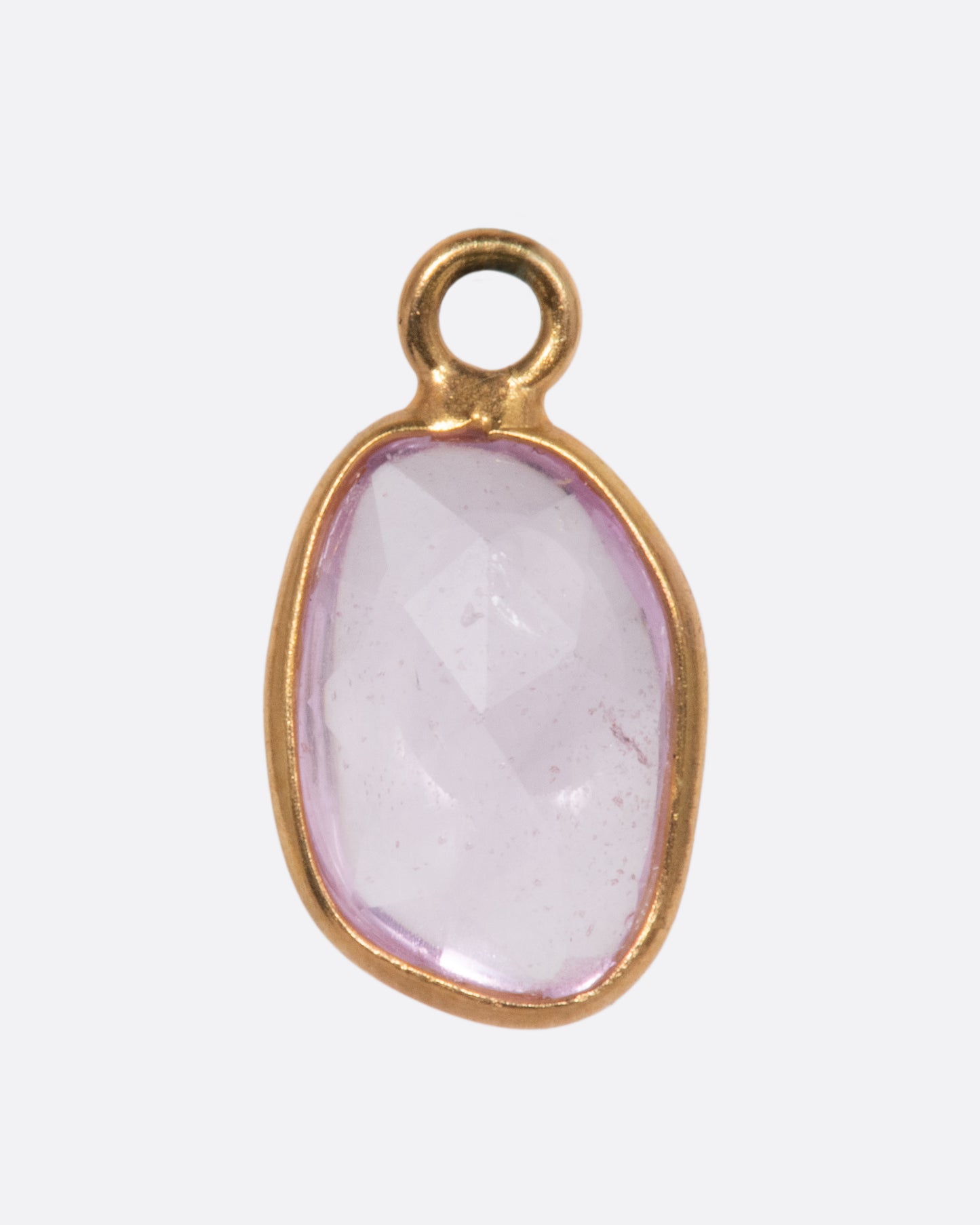 A pink sapphire slice dangle set in yellow gold with a yellow gold bail. Shown from the back.