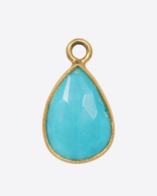 A turquoise teardrop shaped dangle set in yellow gold with a yellow gold bail. Shown from the front.