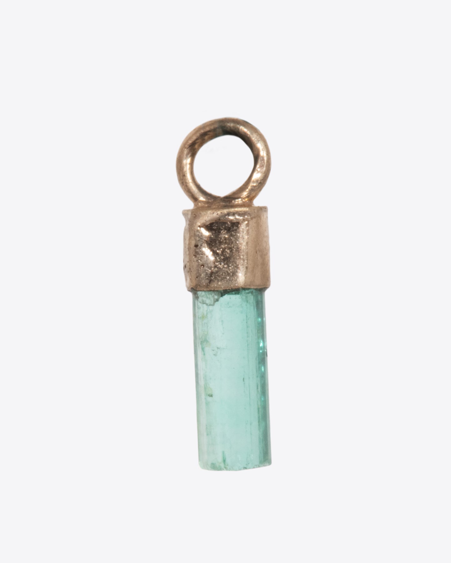 A Colombian emerald dangle in a yellow gold bail. Shown from the back.