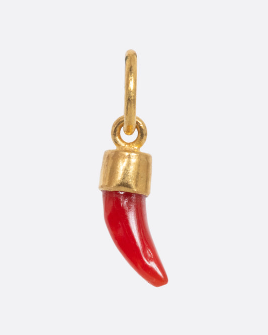 A coral Italian horn dangle with a yellow gold bail and jump ring. Shown from the front.