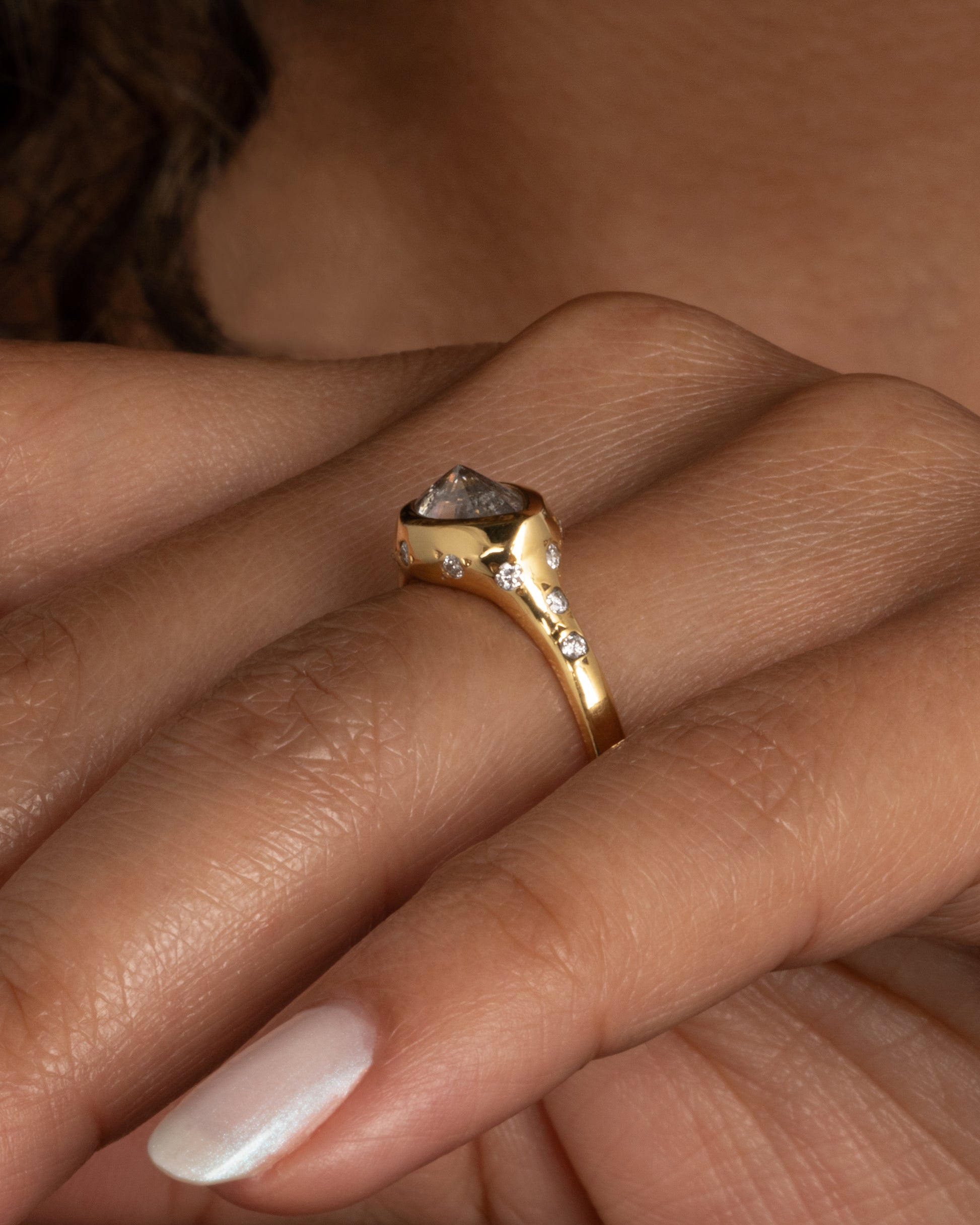This ring is made extra special by the inverted, east-west diamond at its center. Shown worn on a finger.