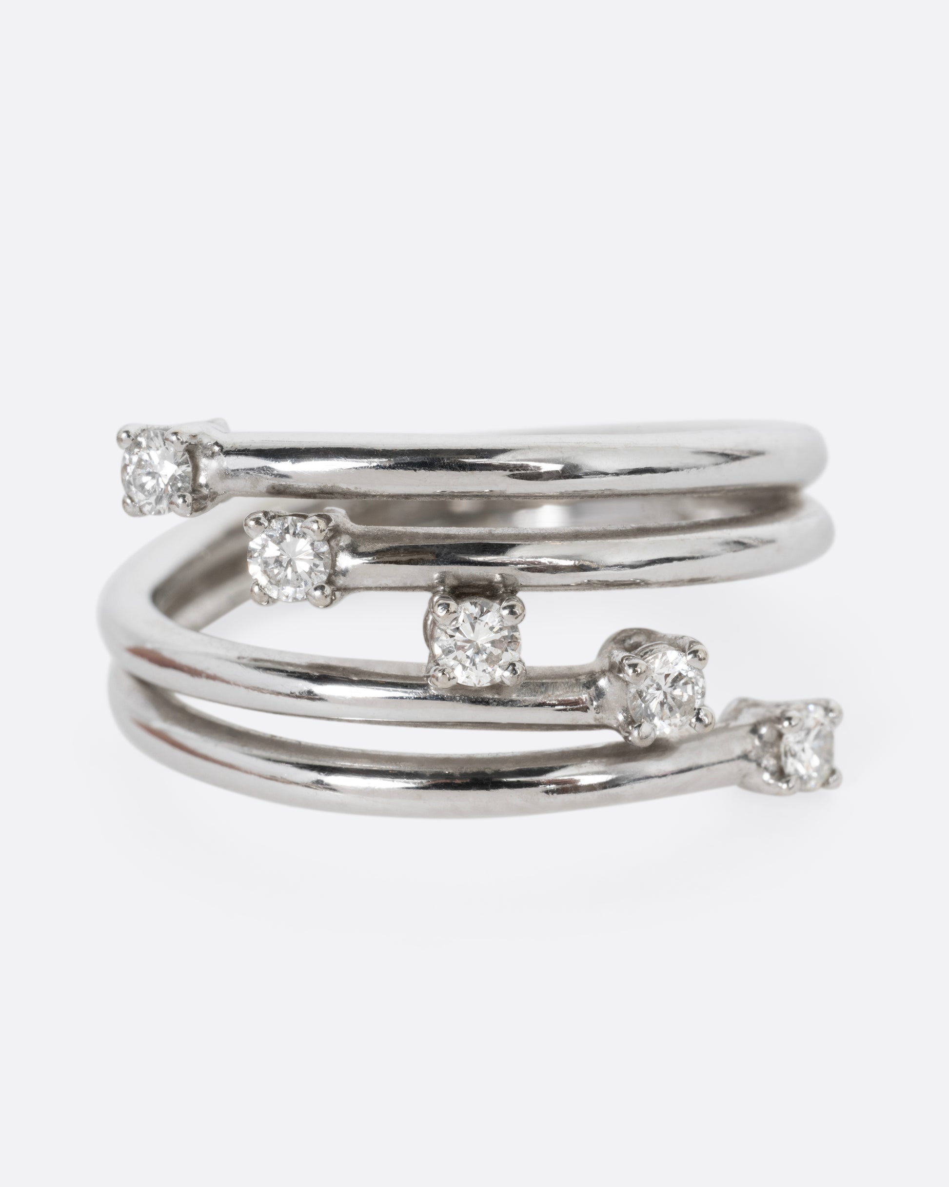 A white gold wrap ring with five diagonal prong set diamonds, shown from the front.
