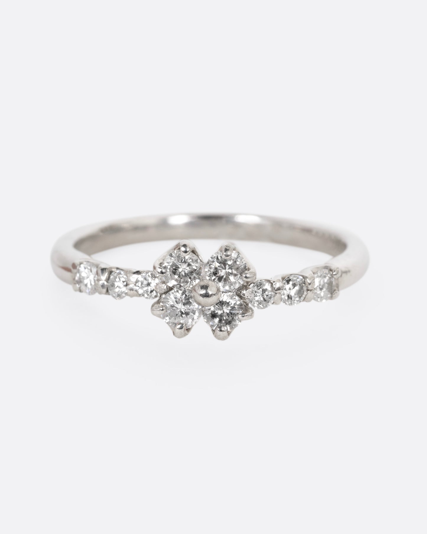 A platinum ring with an 'X' shape and diamonds, shown from the front.