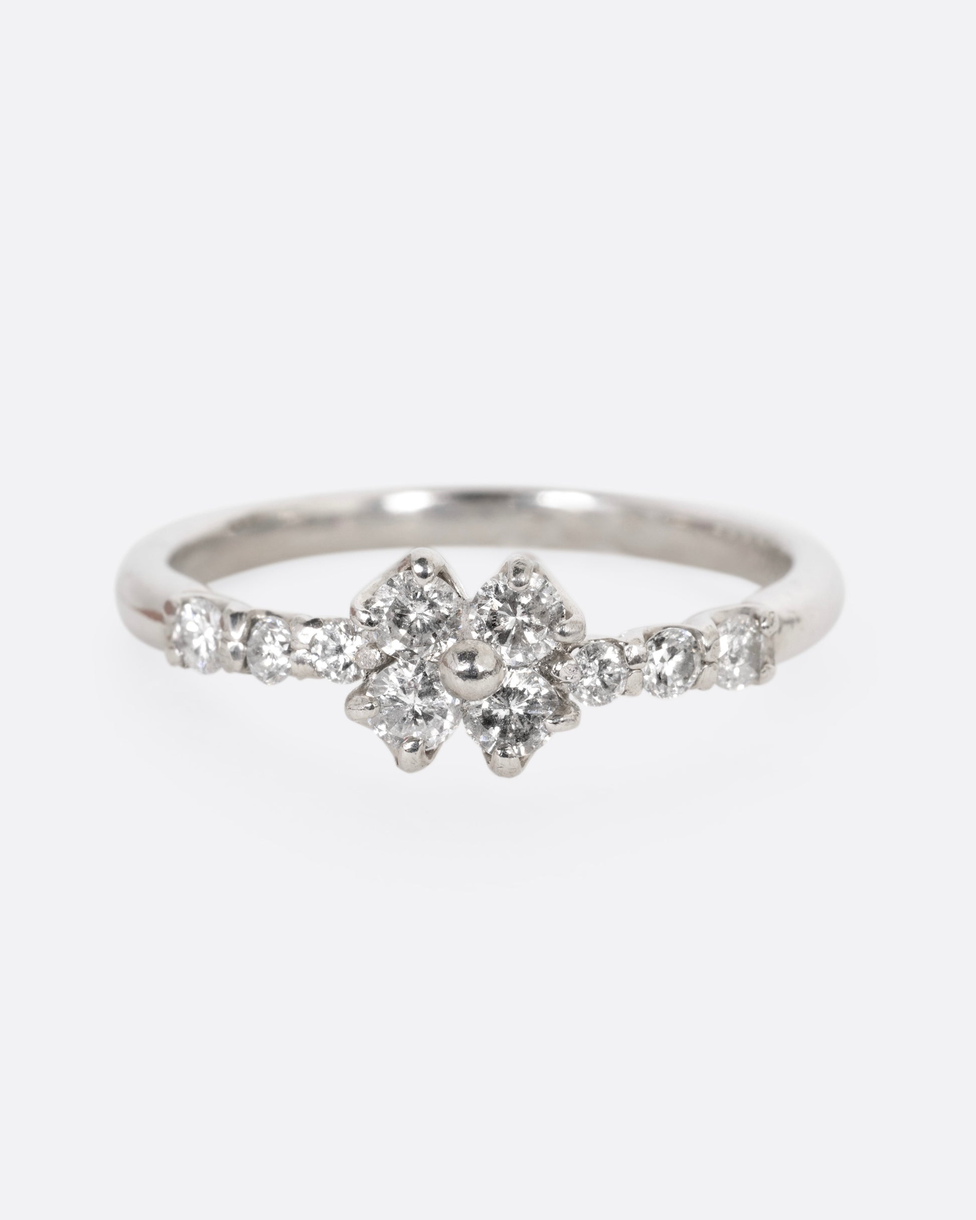 A platinum ring with an 'X' shape and diamonds, shown from the front.
