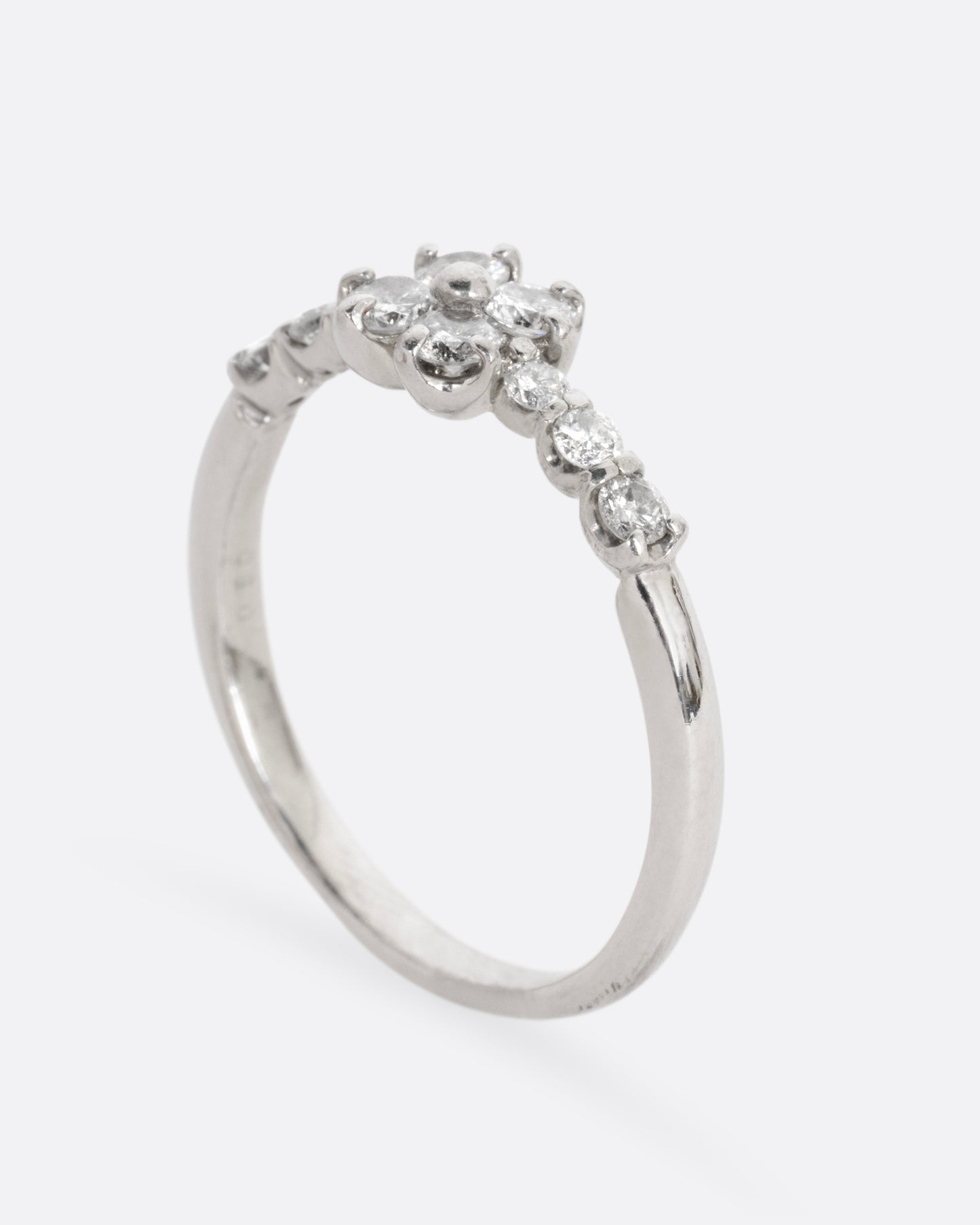 A platinum ring with an 'X' shape and diamonds, shown from the side standing up.