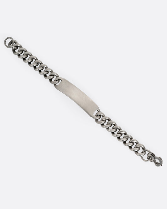 A silver curb chain ID bracelet, shown from the front open.