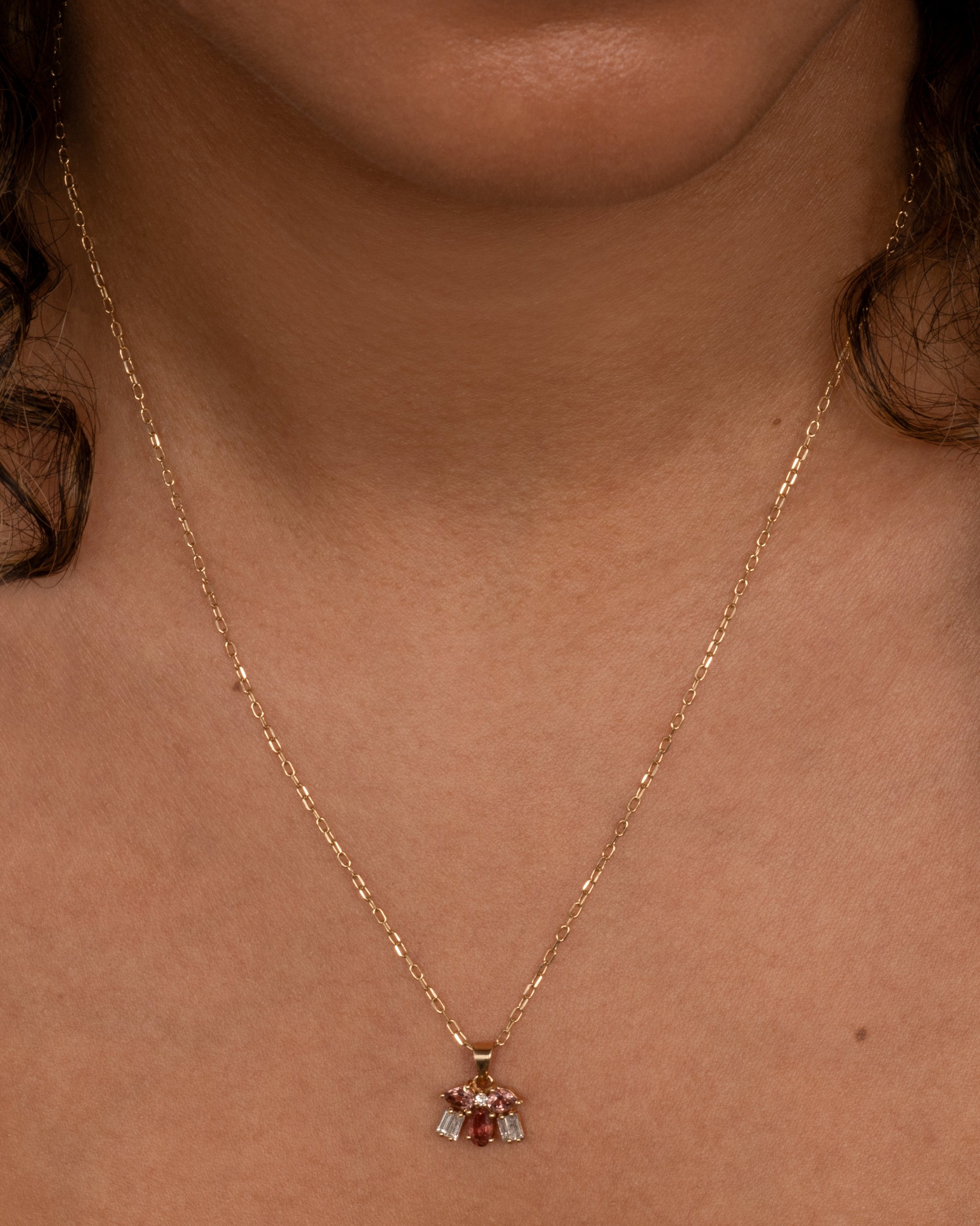 A tiny creature made from tourmalines and diamonds, hanging on a delicate chain. Shown worn around the neck.