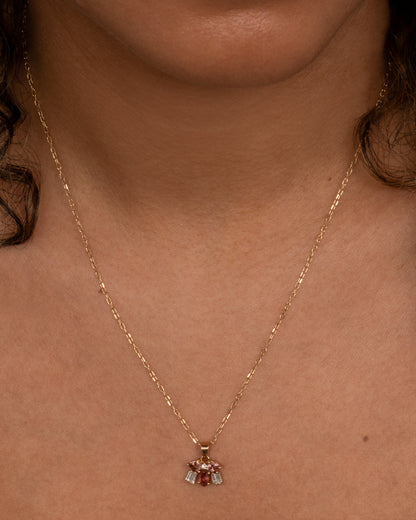 Yellow gold pink stone and diamond cluster necklace worn at the collarbone
