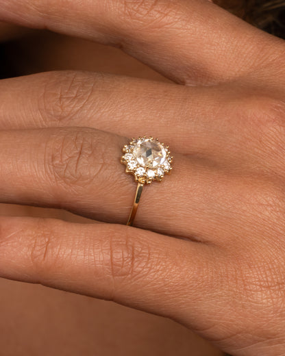 Yellow gold diamond halo ring worn on a finger