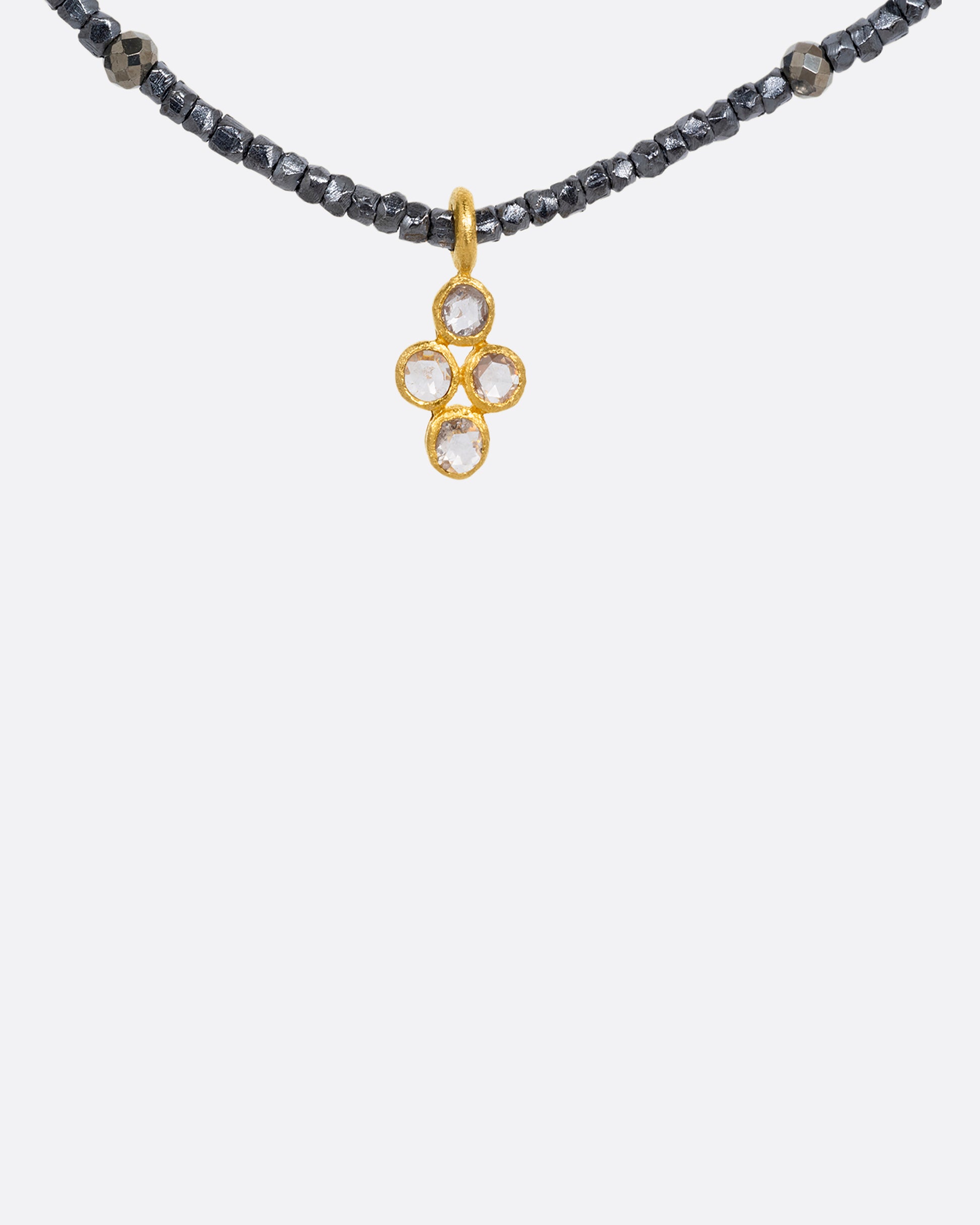 A pyrite bead necklace with a diamond quartet charm at the center. Shown from the front.
