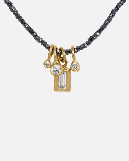 A necklace with oxidized silver Hill Tribe beads and a cluster of four brilliant white diamond charms. Shown from the front.