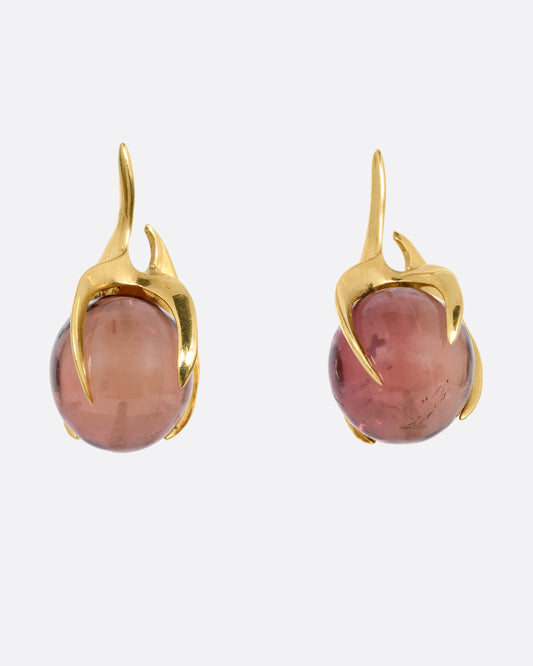 A pair of yellow gold stud earrings with claw settings cradling two tourmaline spheres. Shown from the front.