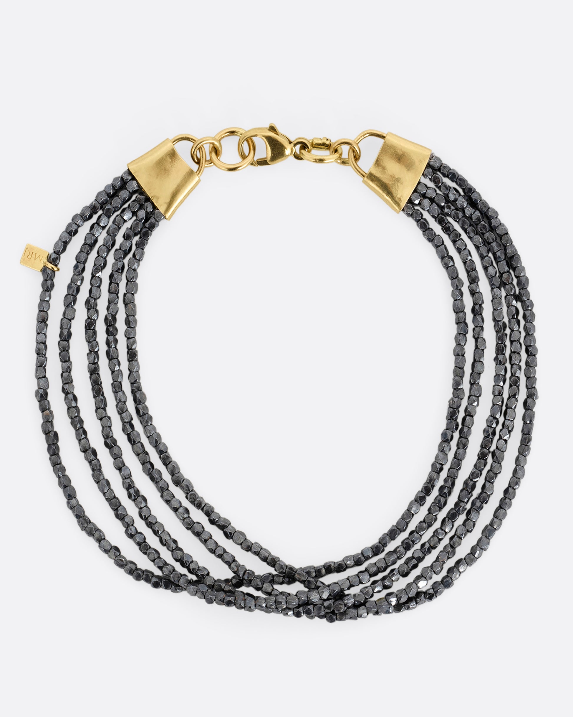 A bracelet with five strands of oxidized silver beads converging at  yellow gold capped ends with a lobster clasp. Shown from the top.