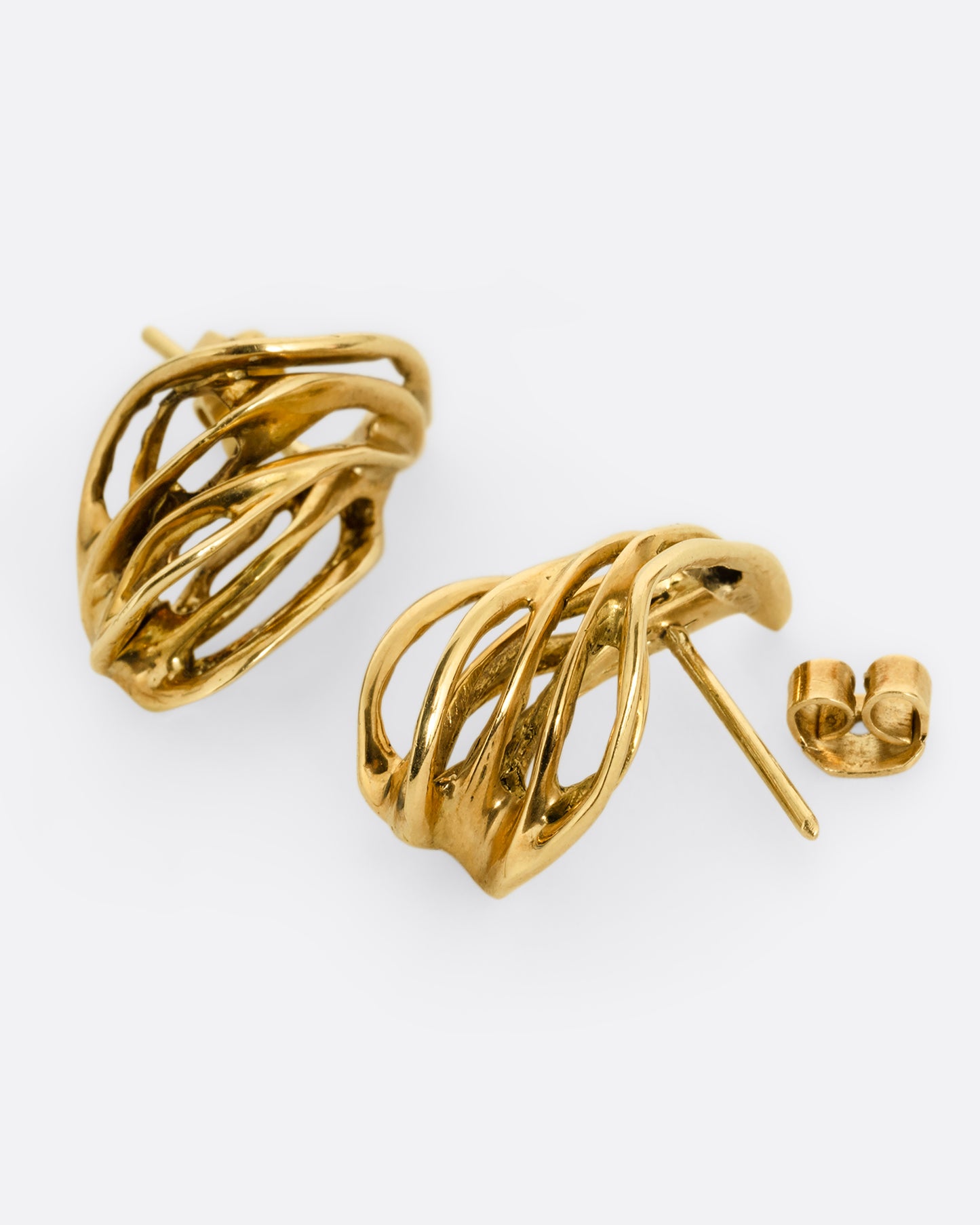 A pair of yellow gold stud earrings with clusters of  intertwined gold strands. One earring is shown from the front, the other is shown open from the side.