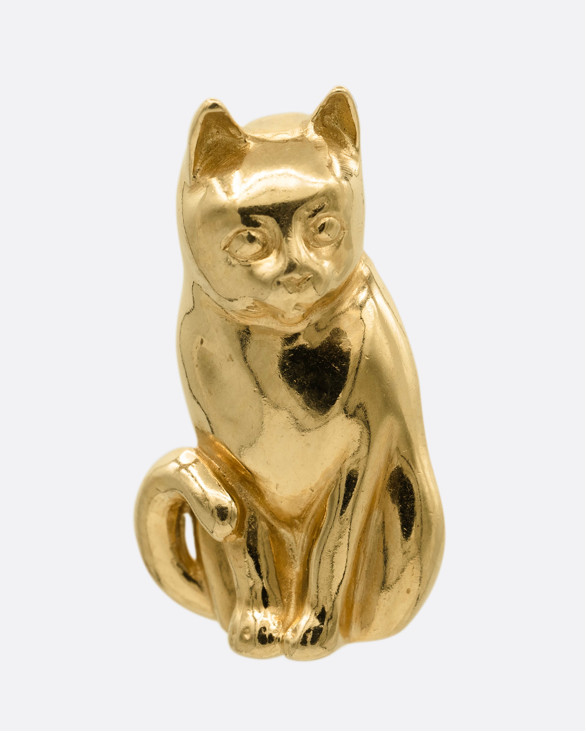 A yellow gold cat charm, shown from the front. 