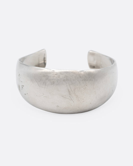 A silver cuff bracelet with smooth edges, shown from the front.