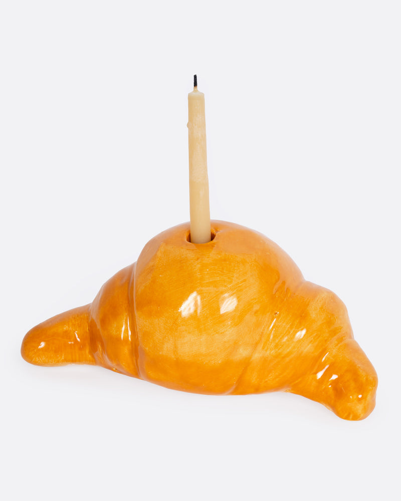 Diego Nine ceramic croissant candle holder, a glossy golden croissant holding a taper candle