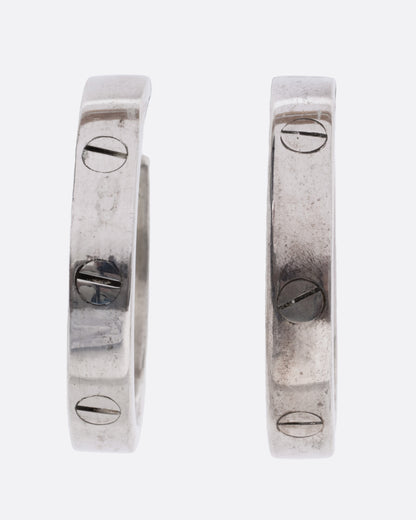 A pair of silver hoop earrings with a motif mimicking flat head screws, shown from the front.