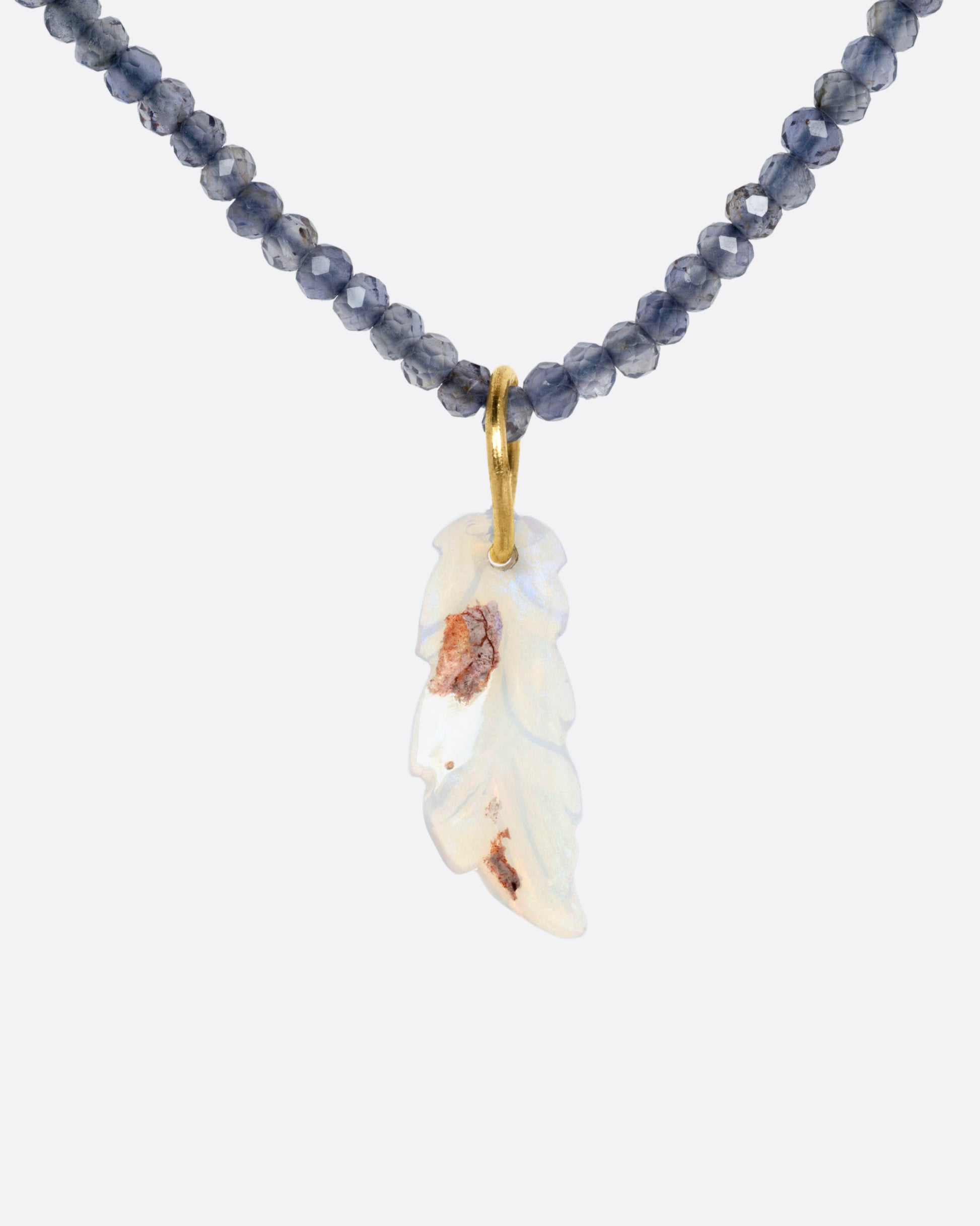 A beaded iolite necklace with a handcarved opal leaf pendant, shown from the front.