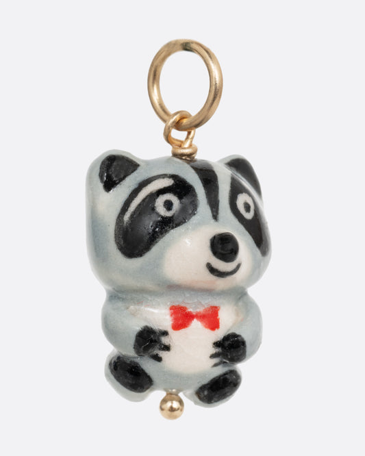 A hand painted raccoon charm with a bow tie. Shown from the front.