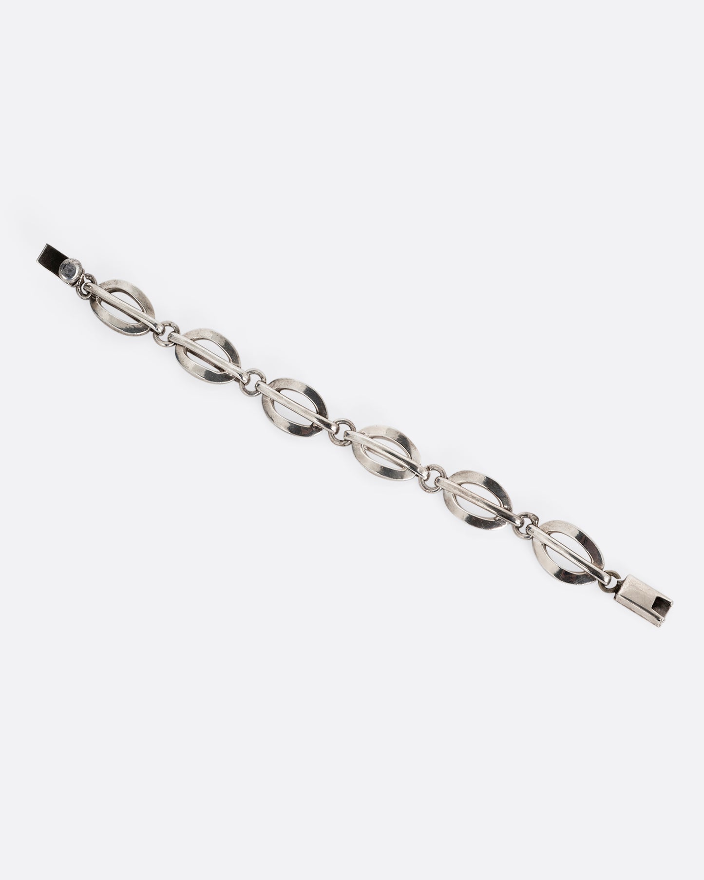A silver split oval link bracelet. Shown open lying flat.