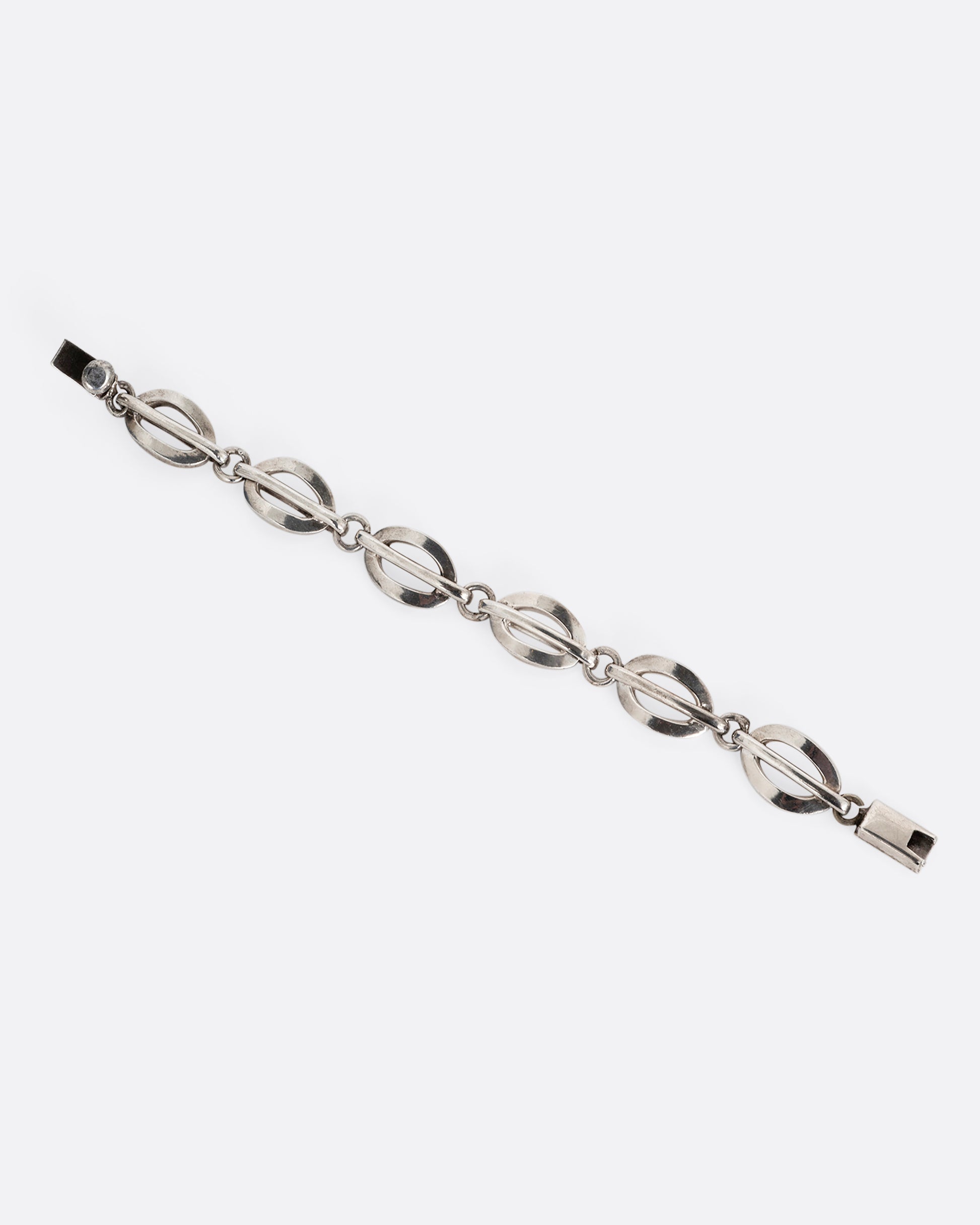 A silver split oval link bracelet. Shown open lying flat.