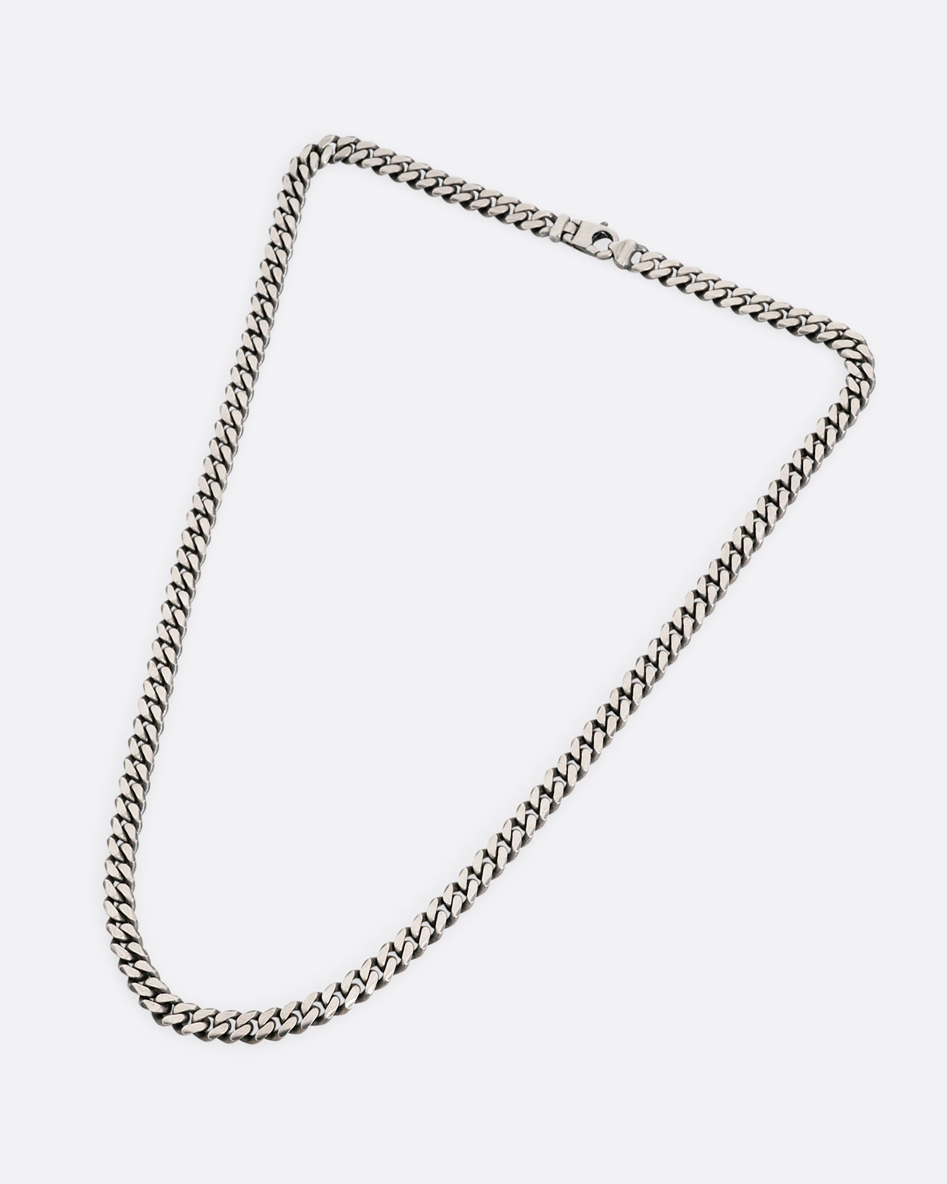 A silver curb chain necklace shown from the front.