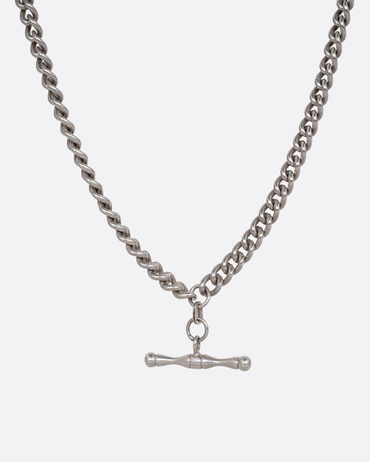 A silver curb chain pocket watch curb chain necklace with a T-bar on one end. Shown from the front.