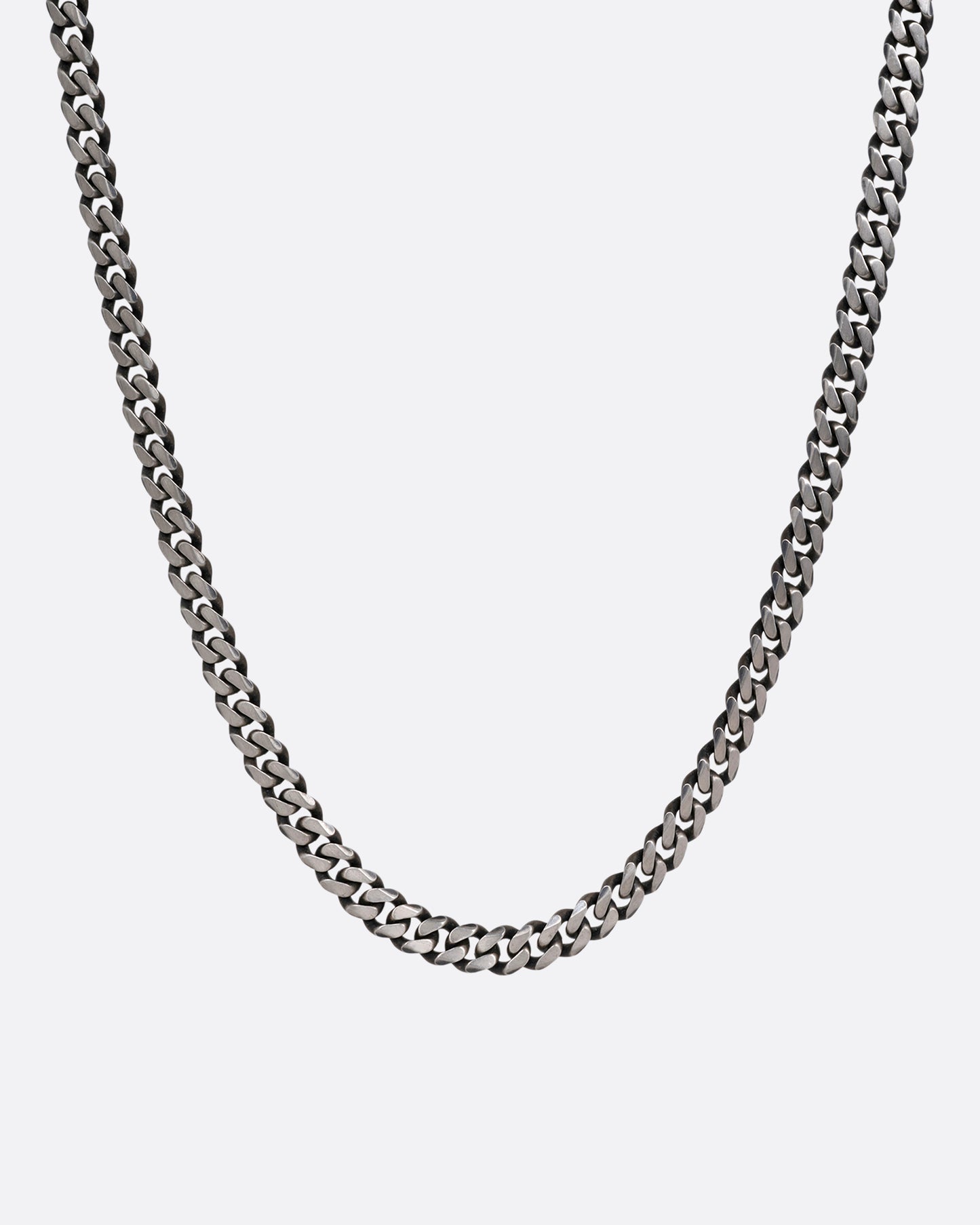 A silver curb chain necklace shown from the front.
