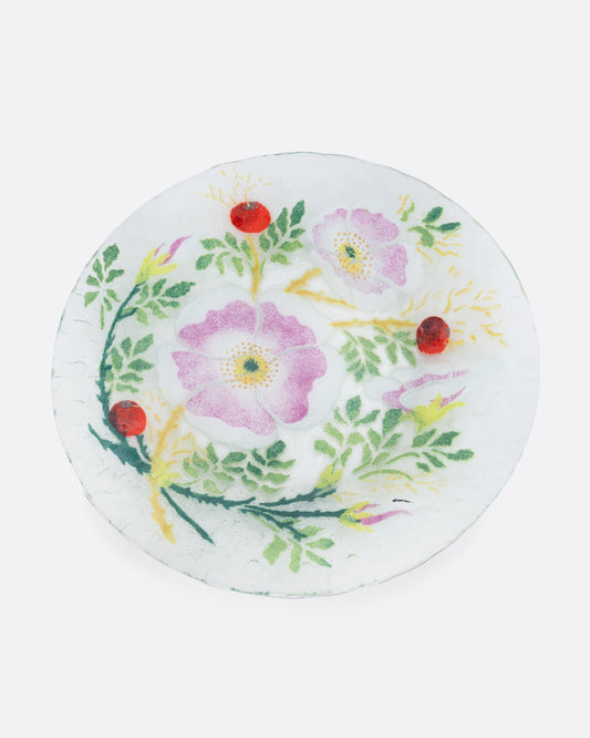 A clear fused glass plate with a floral motif. Shown from the top.