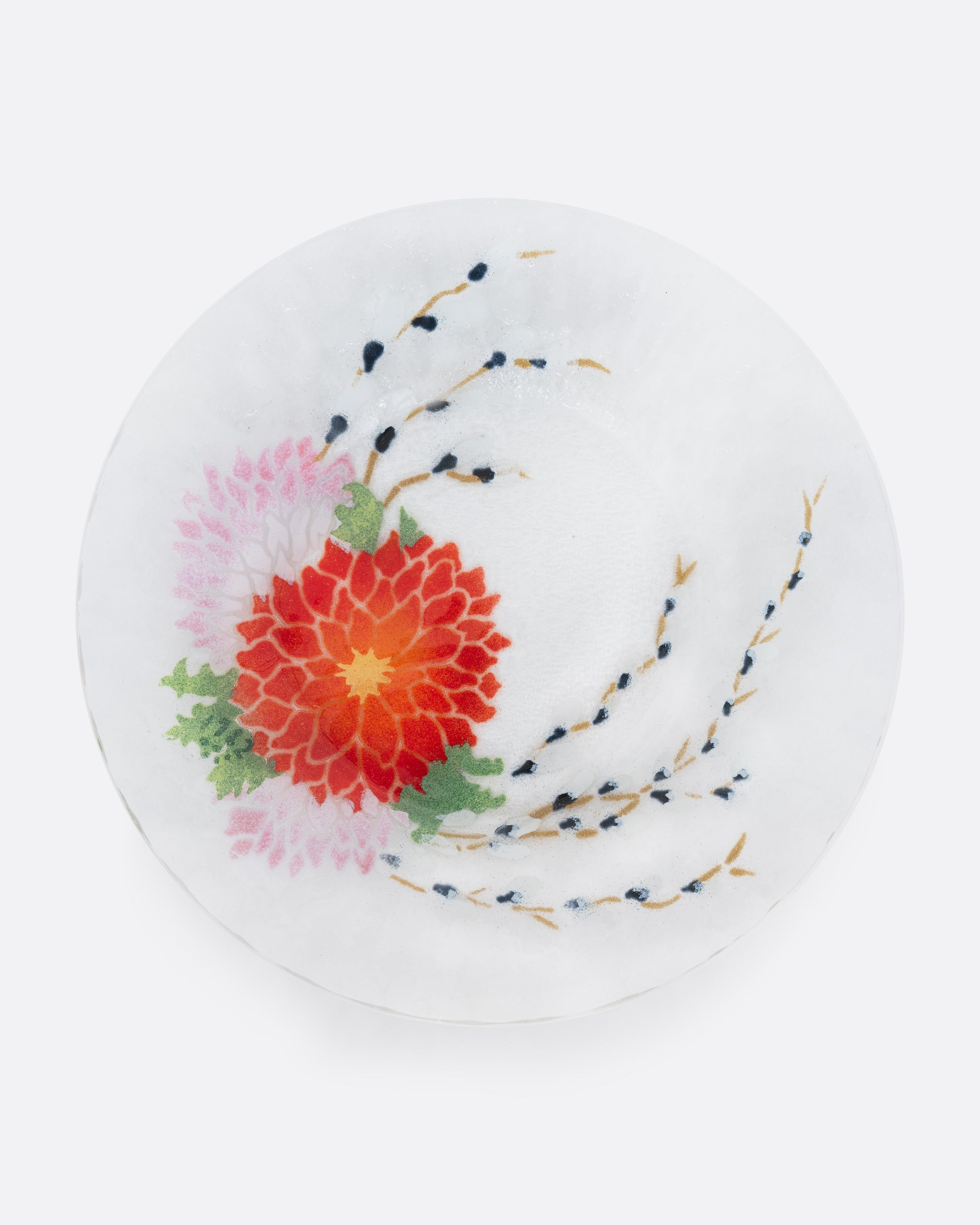A clear fused glass plated with a chrysanthemum motif. Shown from the top.