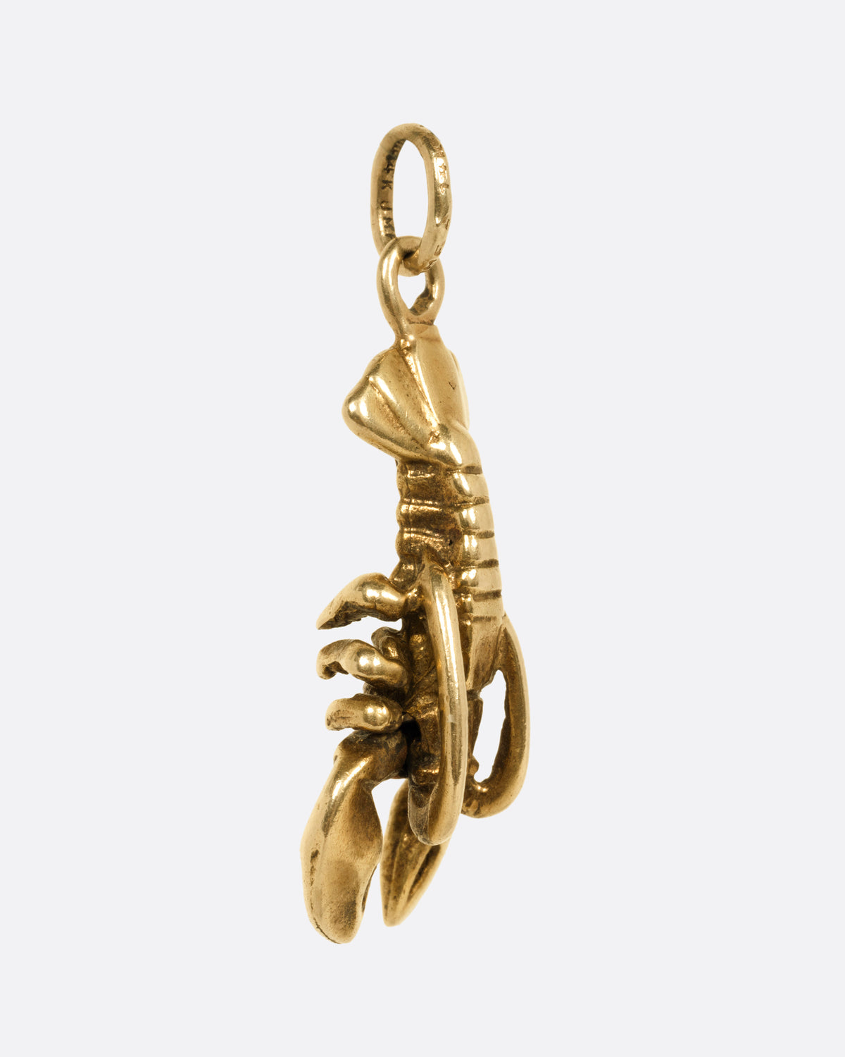 A yellow gold lobster pendant, shown from the side.