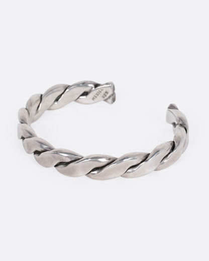 A silver twisted cuff bracelet, shown from the side.