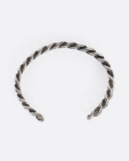 A silver curb chain cuff bracelet shown from the top.