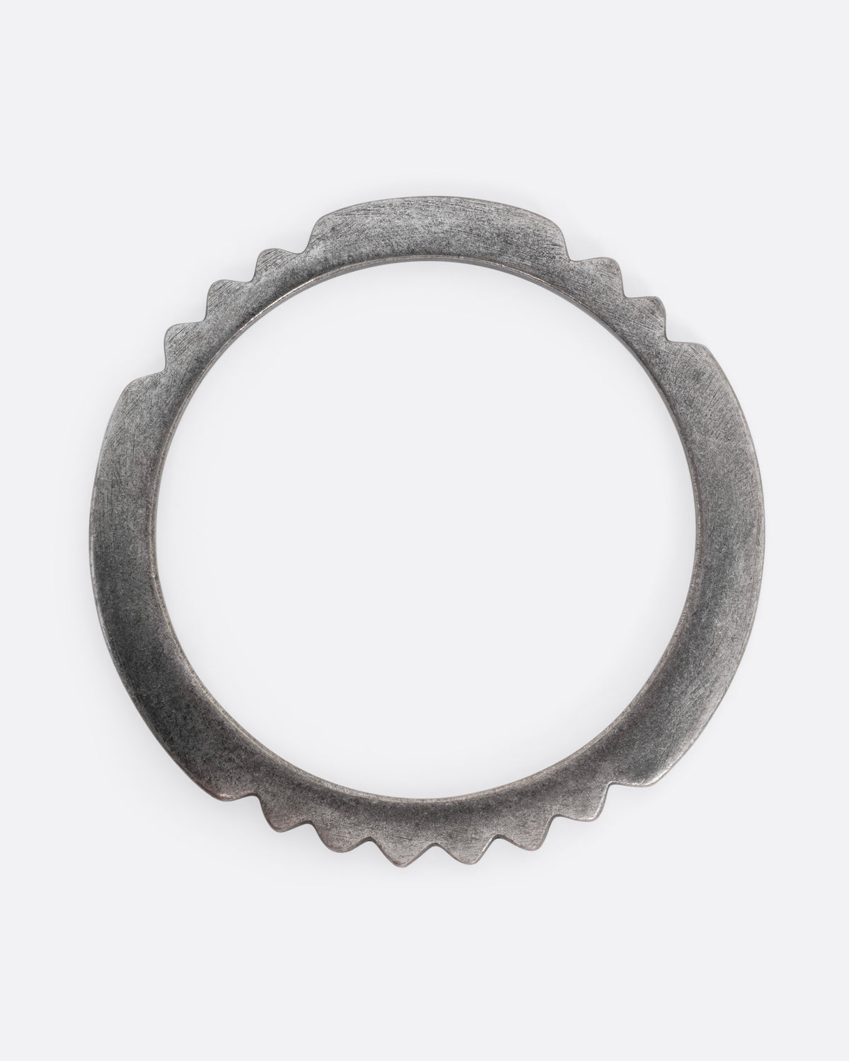 A silver bangle bracelet with a zigzagging edge, shown from the top.