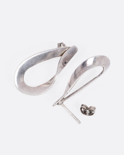 A pair of silver twisted dimensional drop studs, shown from the side with one earring open.
