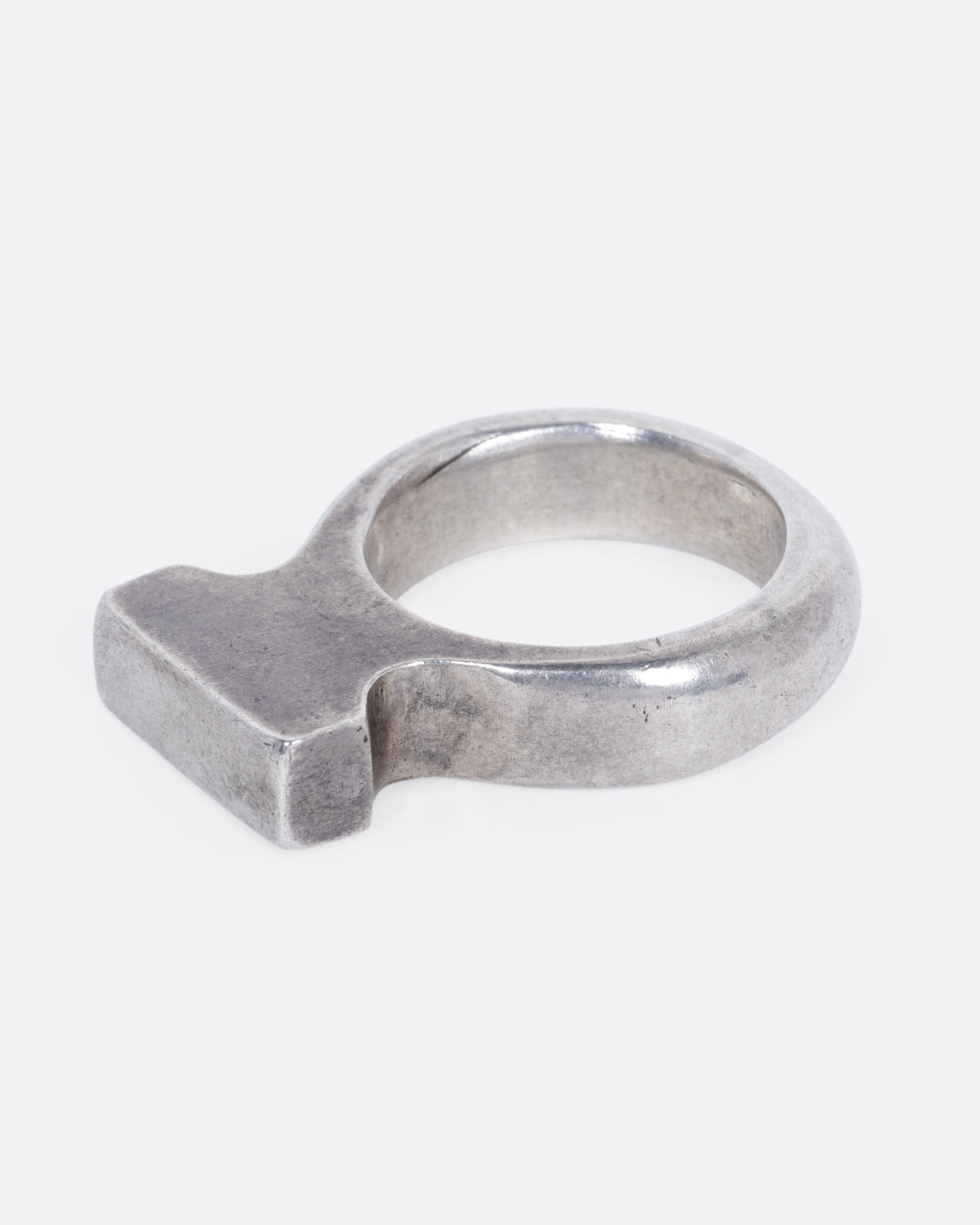 A silver rectangular signet ring with a high silhouette and flat top, shown from the side.