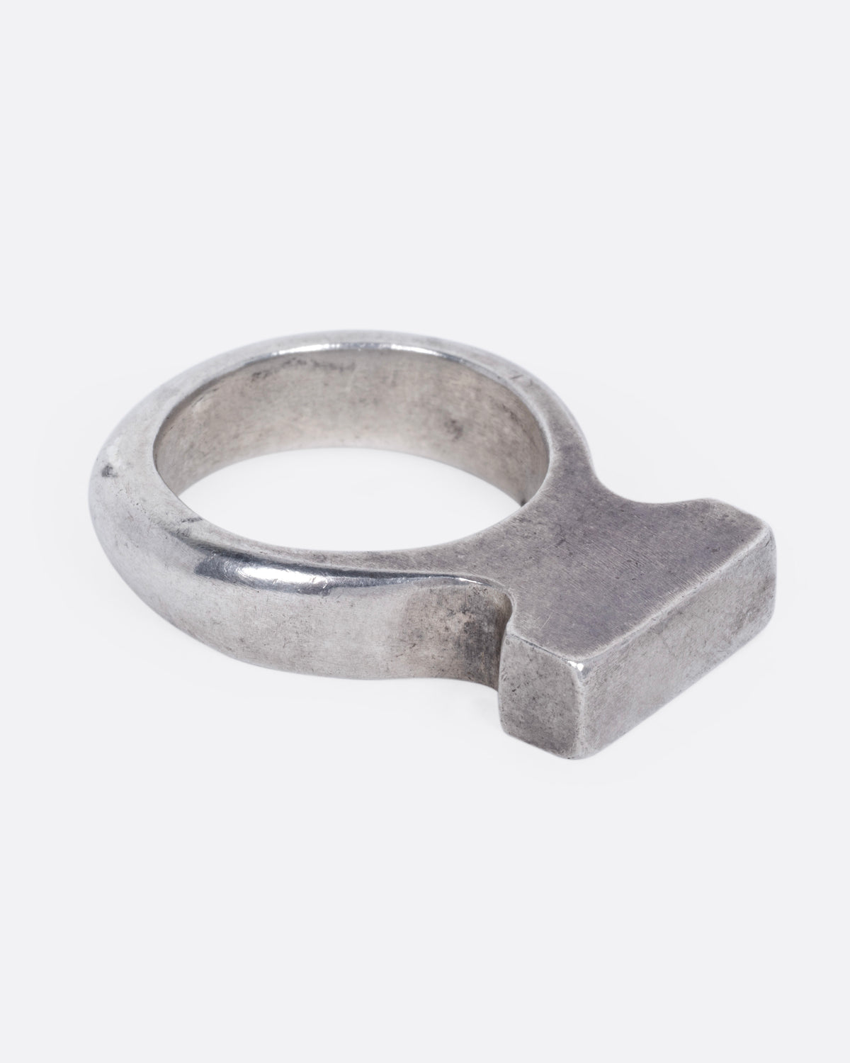 A silver rectangular signet ring with a high silhouette and flat top, shown from the side.
