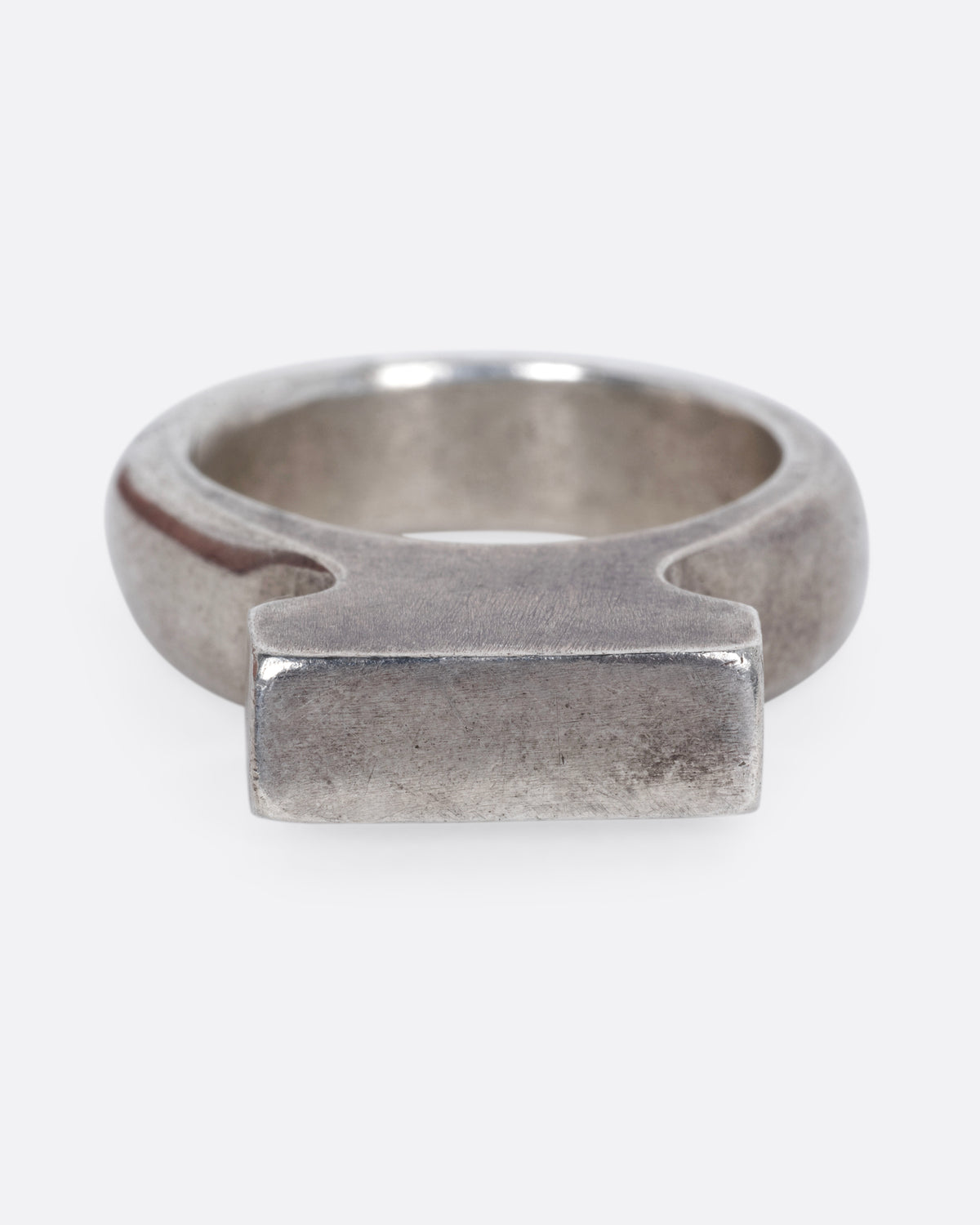 A silver rectangular signet ring with a high silhouette and flat top, shown from the front.