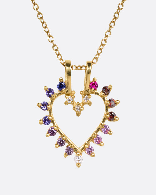 A yellow gold cable chain necklace with a heart shaped pendant with diamonds, rubies, and tourmalines. Shown from the front.