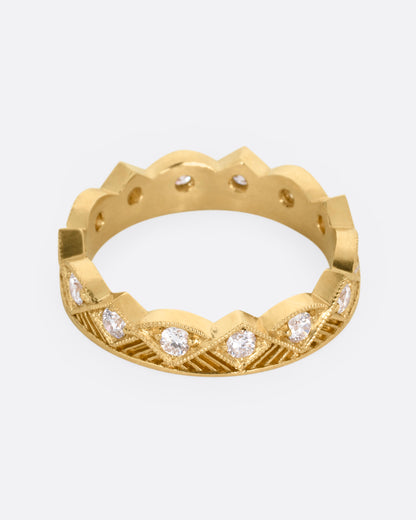 A yellow gold ring with a zigzag design and diamonds throughout, shown from the front.