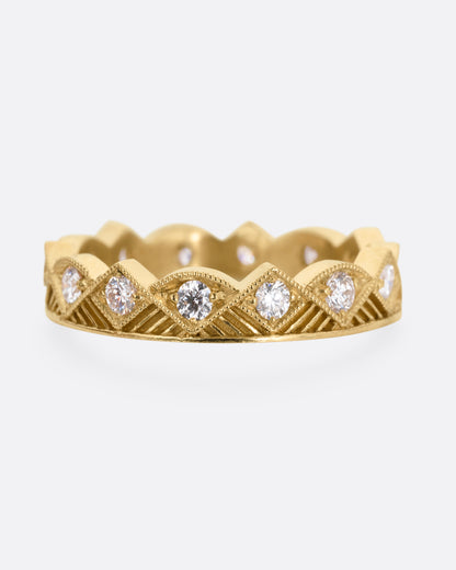 A yellow gold ring with a zigzag design and diamonds throughout, shown from the front.