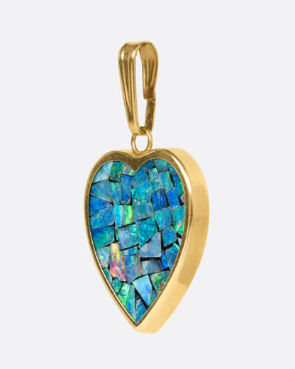 A yellow gold heart shaped pendant with opal inlay, shown from the side.