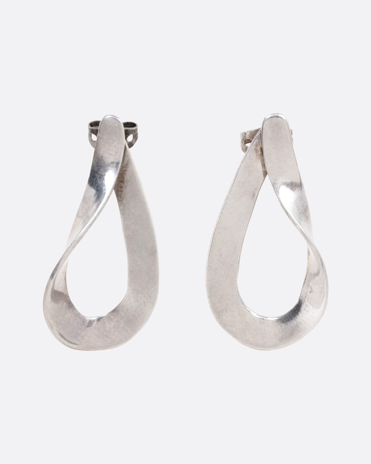 A pair of silver twisted dimensional drop studs, shown from the front.