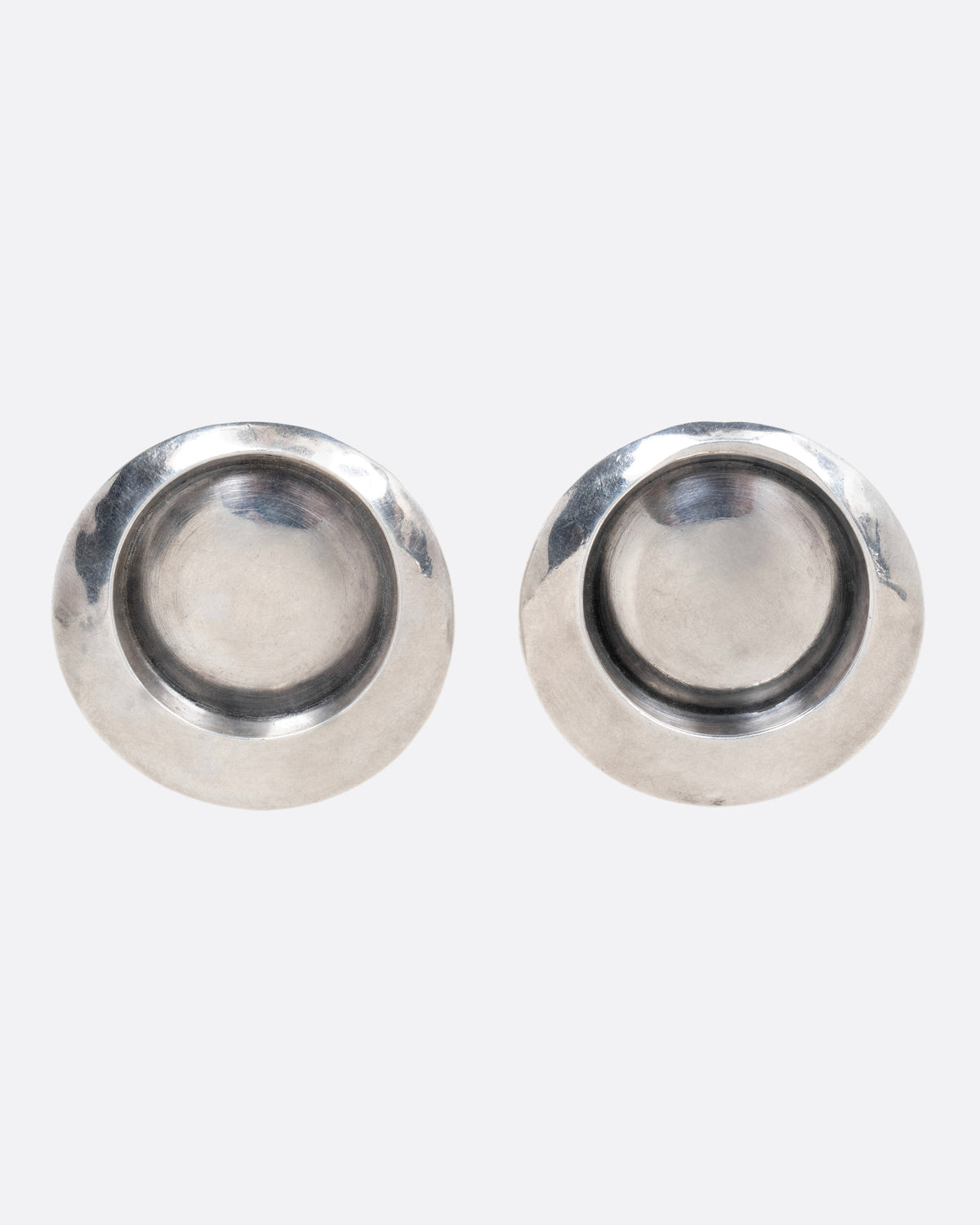 A pair of round stud earrings with recessed centers, shown from the front.