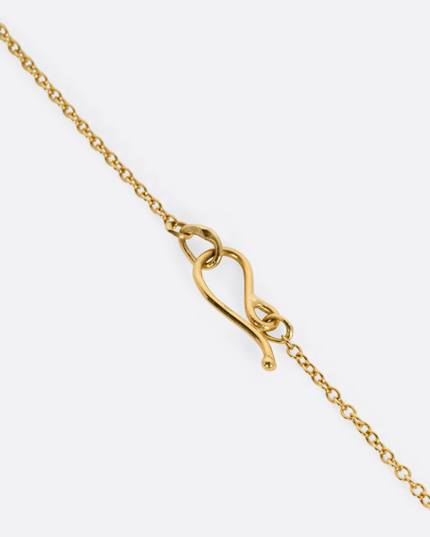 A gold chain necklace featuring an interlocking heart-shaped clasp.