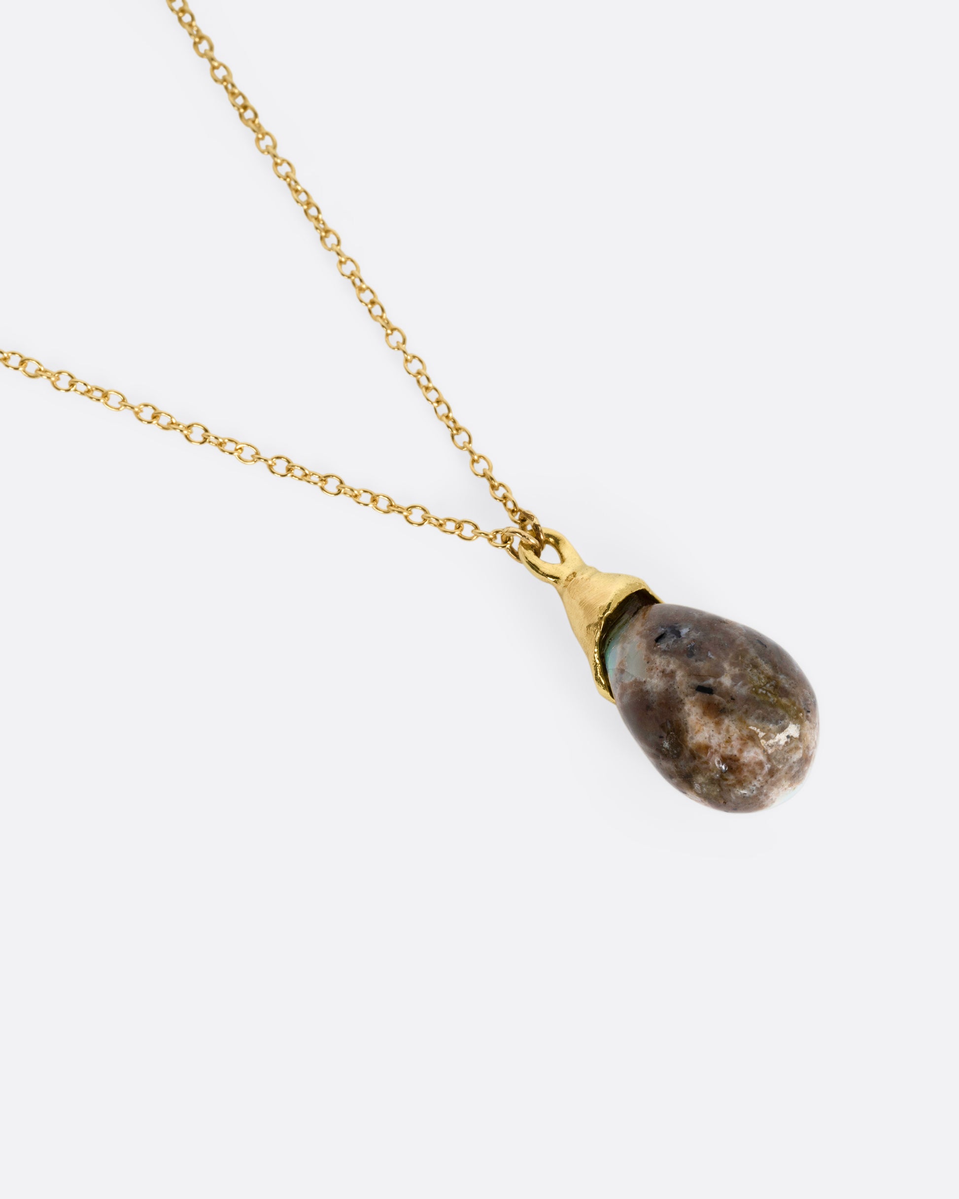 A yellow gold necklace with a teardrop shaped opal pendant, shown from the back.