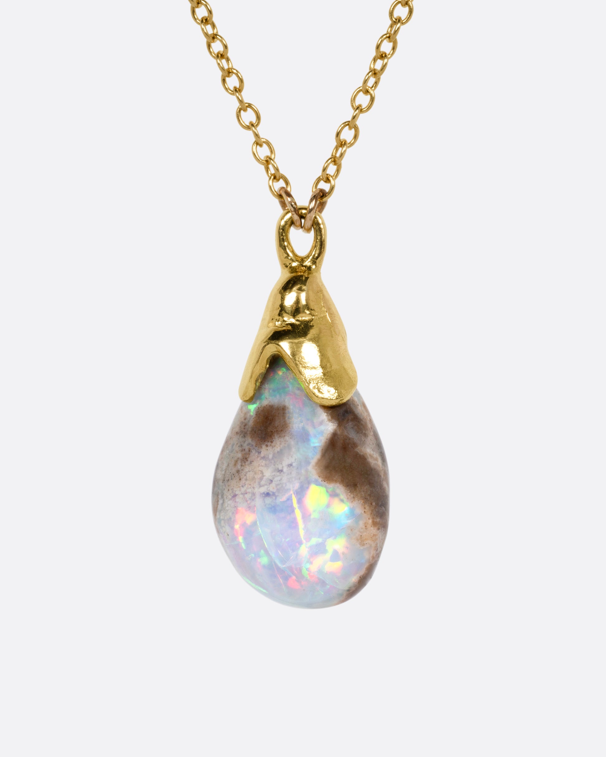 A yellow gold necklace with a teardrop shaped opal pendant, shown from the front.