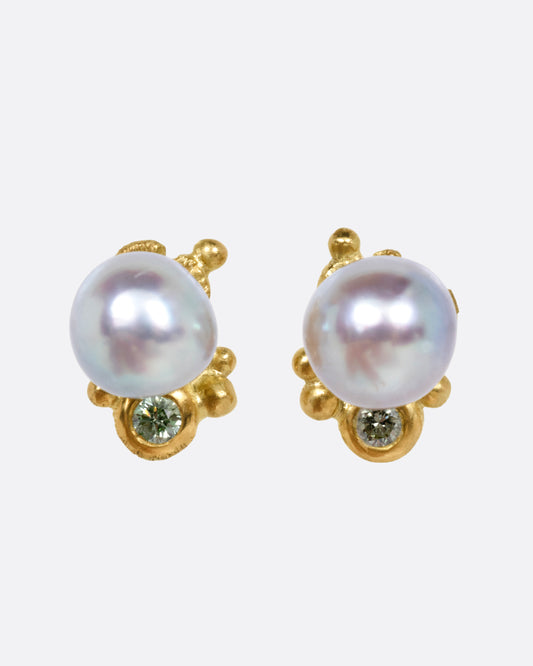A pair of pearl and green diamond yellow gold earrings, shown from the front.